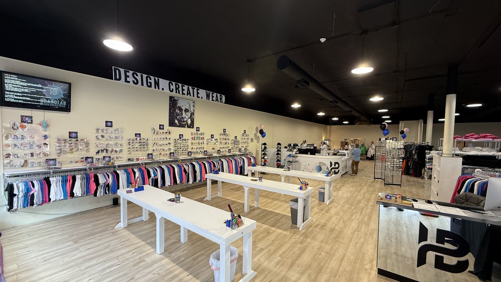 Inside the BRANDLAB shop, design tables and racks of blank garments